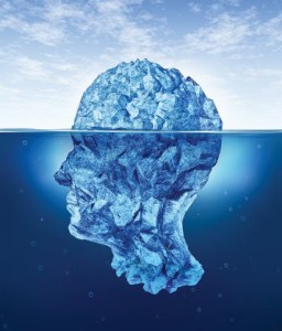 Human brain risks with an iceberg in the shape of a head partialy submerged in the cold arctic ocean as a health care medical symbol for hidden neurological and psychological symptoms.